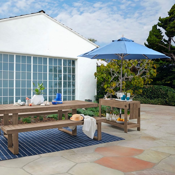 Backyard table setting with large umbrella.