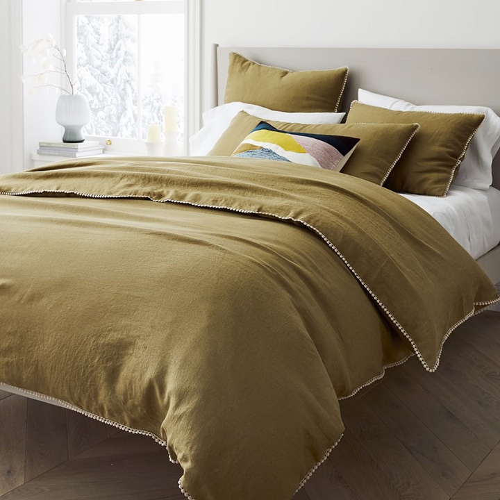 bed with light brown duvet and pillows