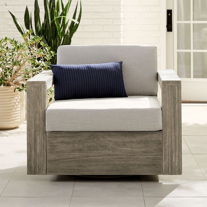 Outdoor chair with striped lumbar pillow.