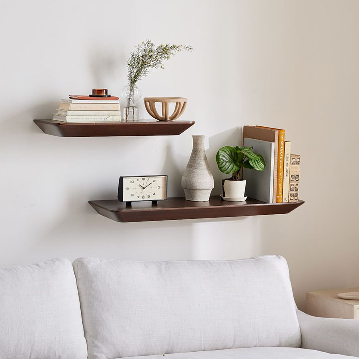 Stacked floating shelves hanging over a sofa.