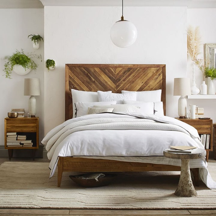 Tall patterned reclaimed-wood headboard in bedroom.
