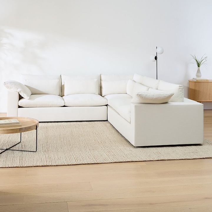 Cream sofa, beige area rug and wood coffee table. Cream sofa, beige area rug and wood coffee table.