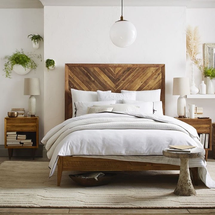 Tall patterned reclaimed-wood headboard in bedroom.