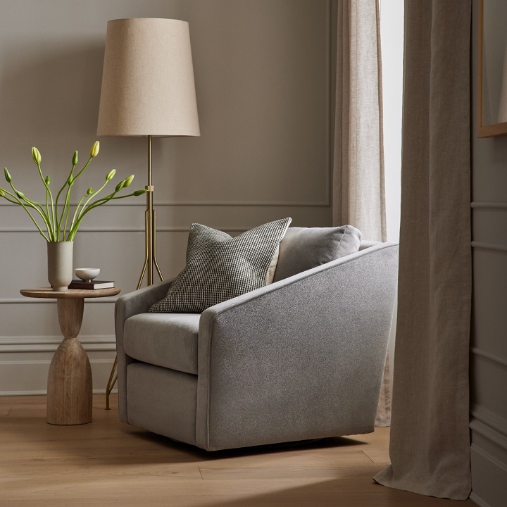 Neutral color accent chair next to modern side table and a floor lamp