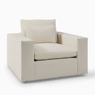 Cream-colored loveseat or small armchair with single back cushion and thick armrests