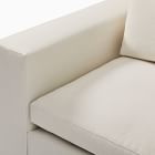 Close-up of armrest and seat cushion meeting at corner with cream upholstery