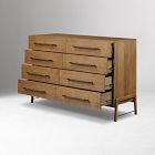 Front view of a wooden dresser with nine drawers arranged in three stacked columns, elevated on legs.