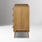 Back/side view of a light wood dresser showing the rear and legs.