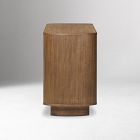 A wooden pedestal-like stool or stand with a rounded base, separate from the dresser.