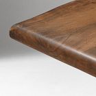 Close-up of rounded rounded table edge with smooth finish and visible wood grain