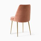 Coral/orange upholstered chair with wooden legs.