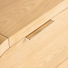 Close-up of handle on light wood dresser with curved edge