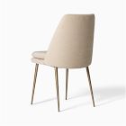 Beige upholstered chair with curved back and wooden legs photographed from side.
