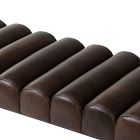 Close-up of several brown tufted leather cushions with stitching.