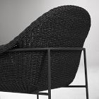 Rear perspective of black woven wicker chair showing metal frame