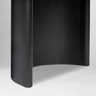 Side view of a curved dark furniture piece with two vertical supports forming a C-shape.