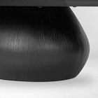 Close-up of the rounded base of a dark pedestal table