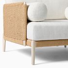 Close-up of woven wicker side panel and light wood leg