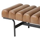Close-up of brown tufted leather cushions on a bench with black metal legs.