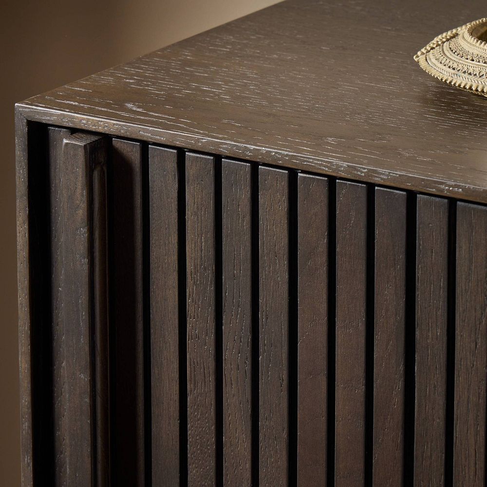 Close-up of the dresser corner showing ribbed drawer fronts and dark wood finish