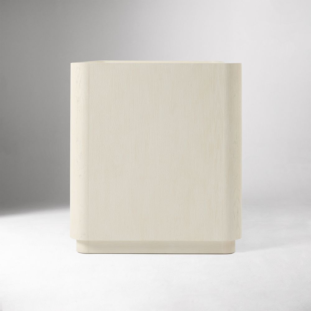 Corner/side view of a white crib conversion kit piece revealing smooth rectangular shape
