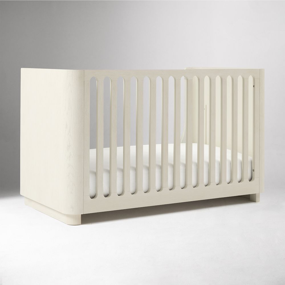 Angled view of the crib conversion kit with slatted front