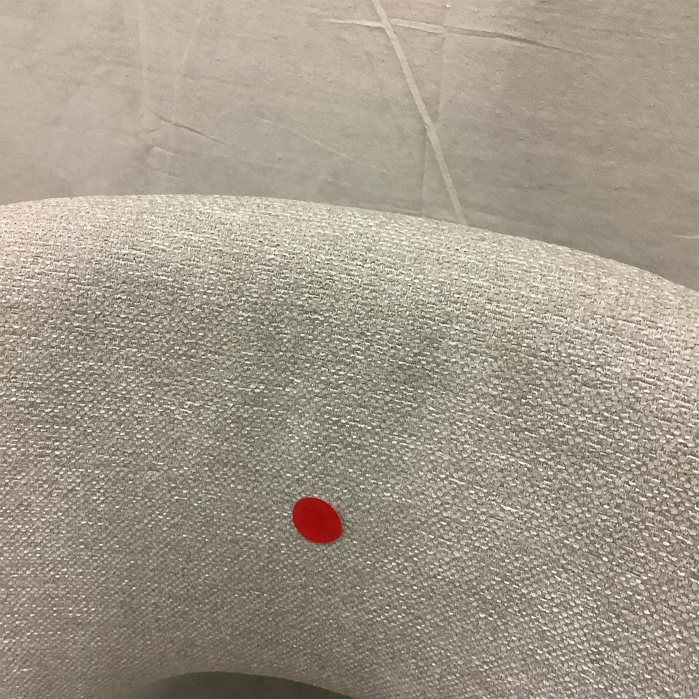 Red circular tag on chair upholstery