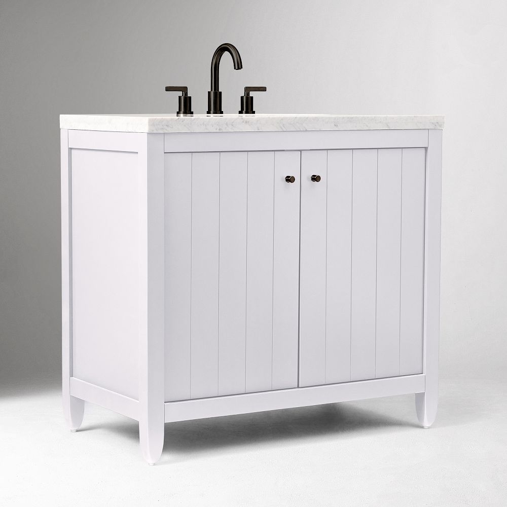 White vanity with marble countertop and bronze hardware
