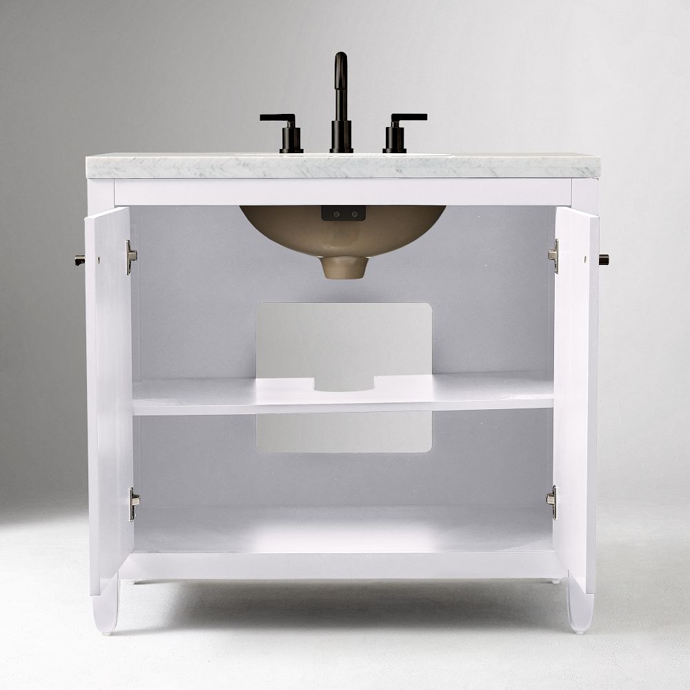 Open vanity showing interior shelf and plumbing