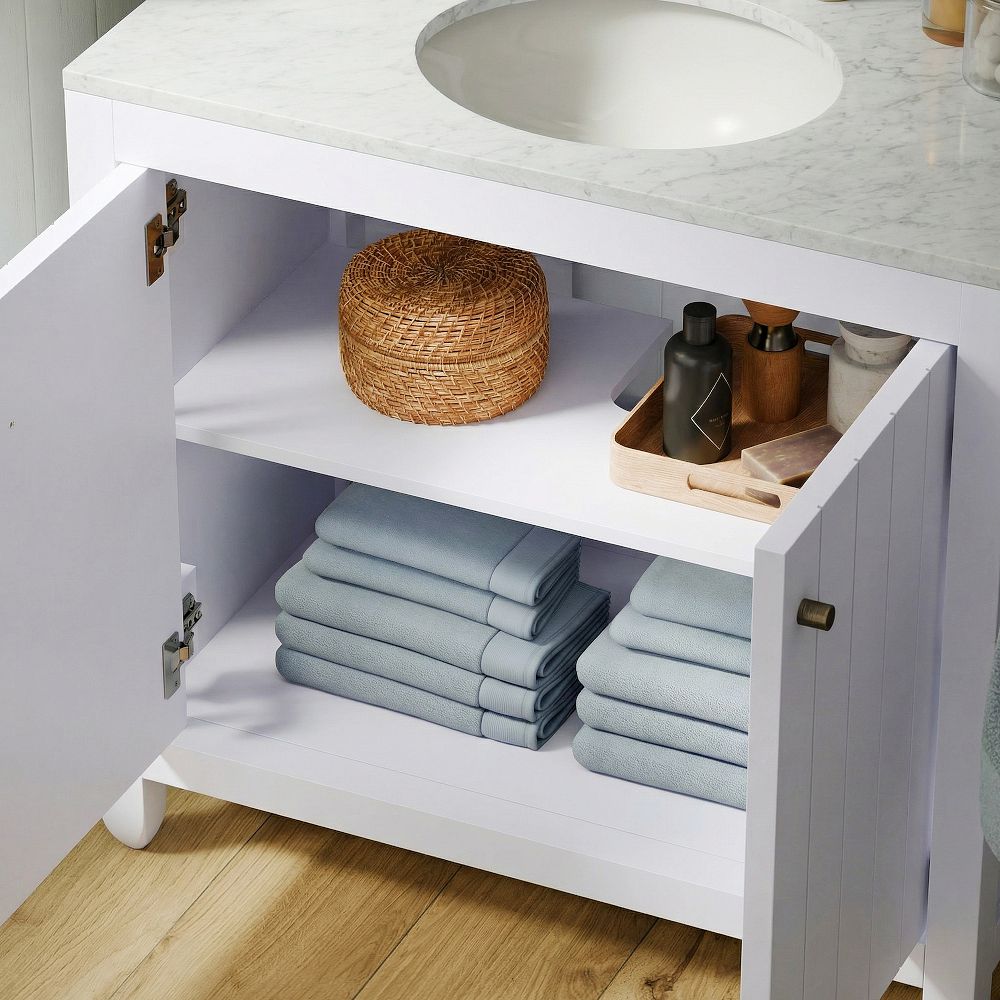 Open vanity cabinet showing storage drawers and items